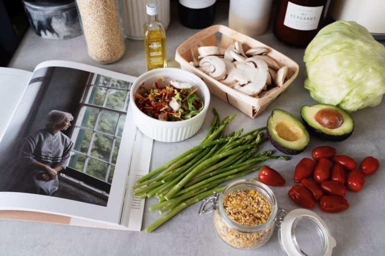 Open cookbook showing a paleo recipe next to chopped vegetables