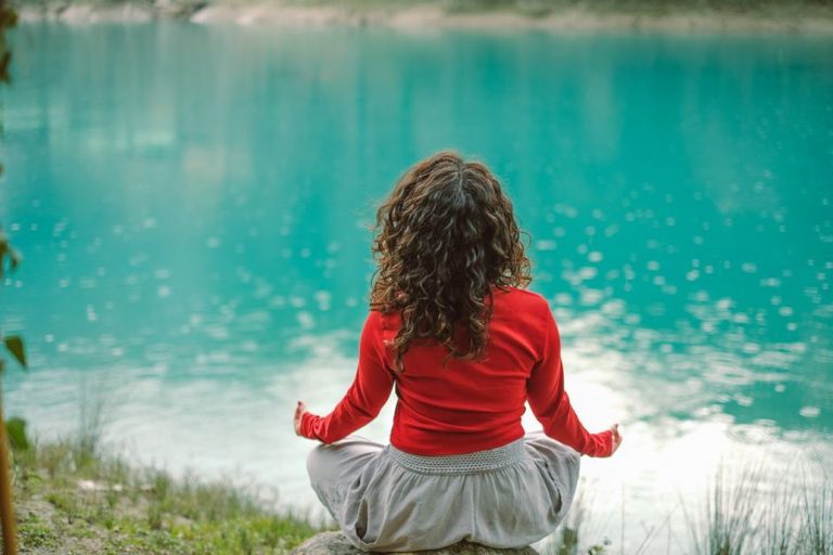 A person meditating outdoors, promoting stress relief