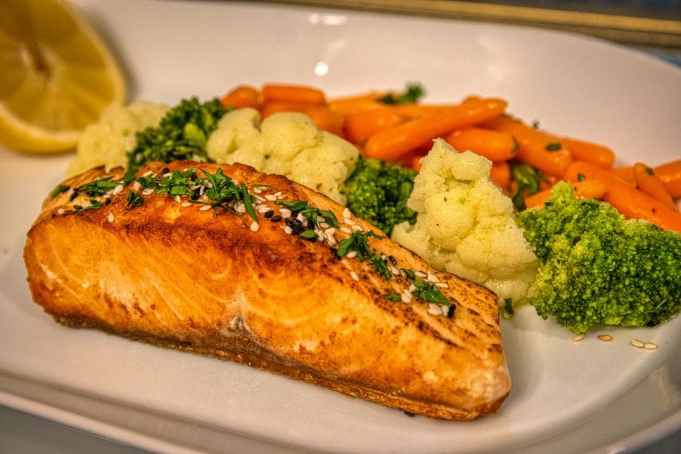 nutrient-dense meal with salmon and colorful vegetables on a white plate