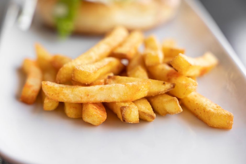 golden brown thick cut fries with crisp edges on a ceramic plate