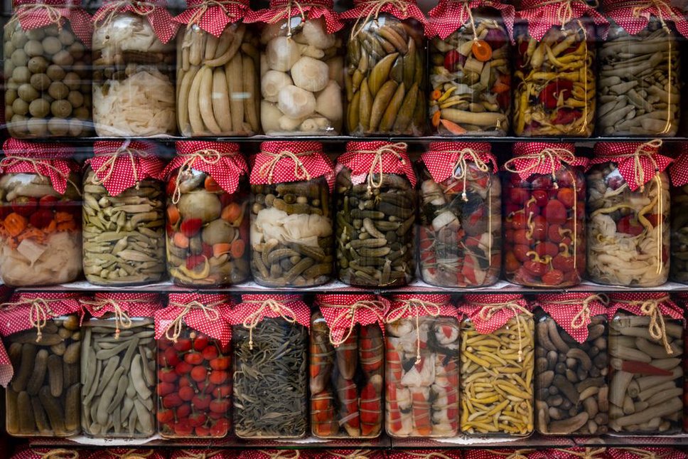 Fermented vegetables in glass jars on a pantry shelf