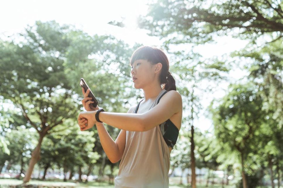 woman looking at wrist device during a nature walk