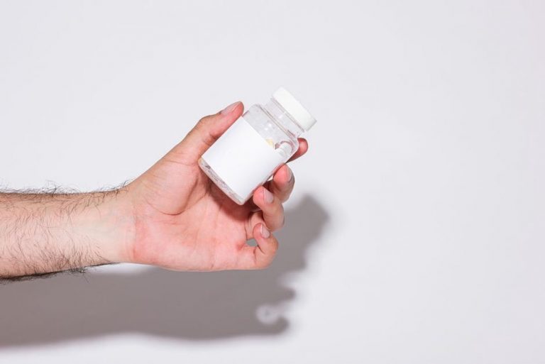woman examining supplement bottle label with uncertainty