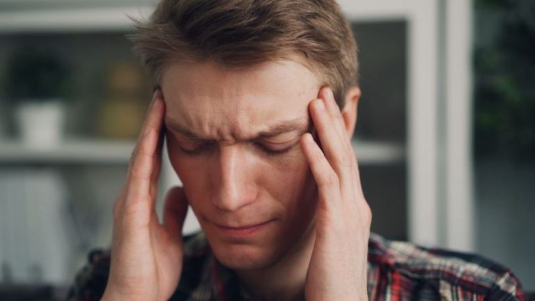Woman pressing temples with a fatigued look