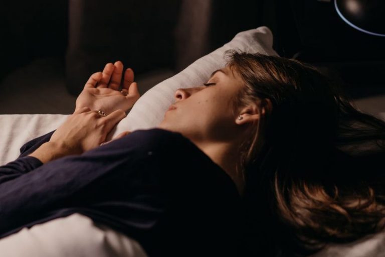 Dark bedroom with blackout curtains and a sleeping figure