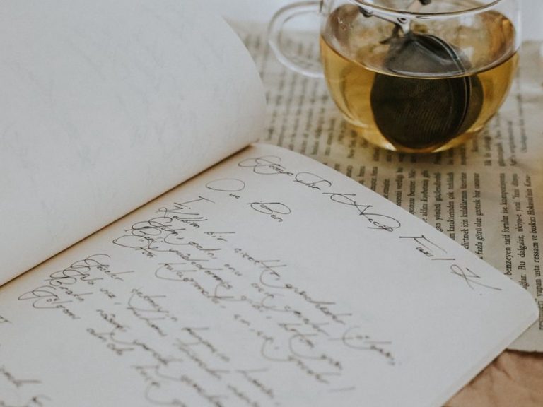 handwritten notes in a food and symptom journal on a wooden table