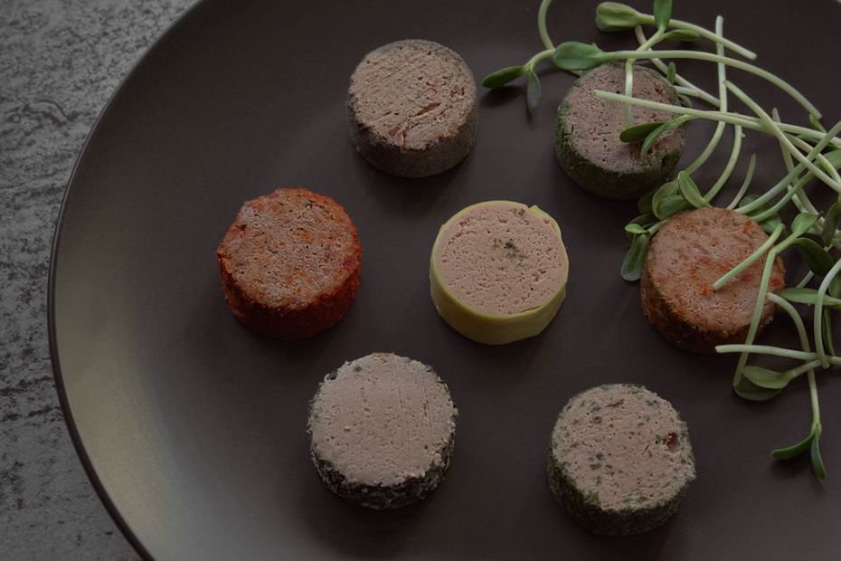 Chicken liver pâté garnished with thyme on a plate with cucumber sticks
