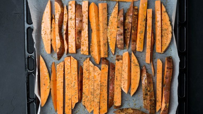 thick cut paleo fries arranged on a lined baking tray before baking