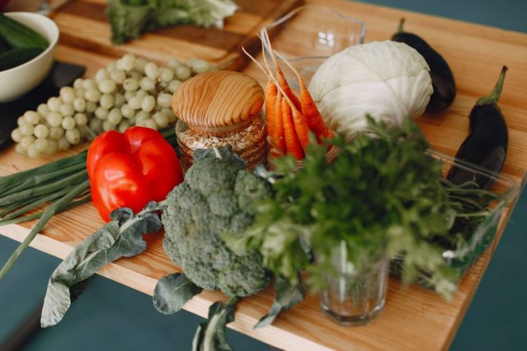 Assorted fresh vegetables and herbs arranged on a rustic table