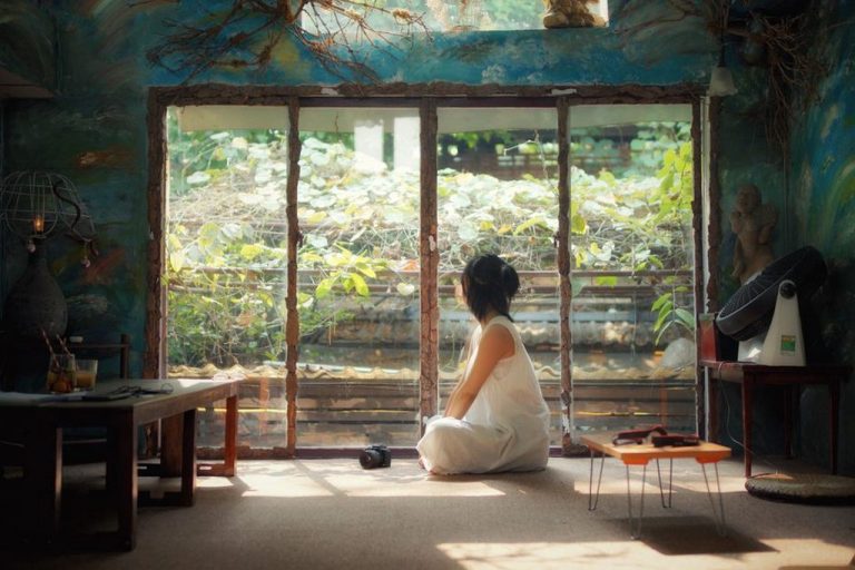 person sitting cross-legged on cushion practicing mindfulness