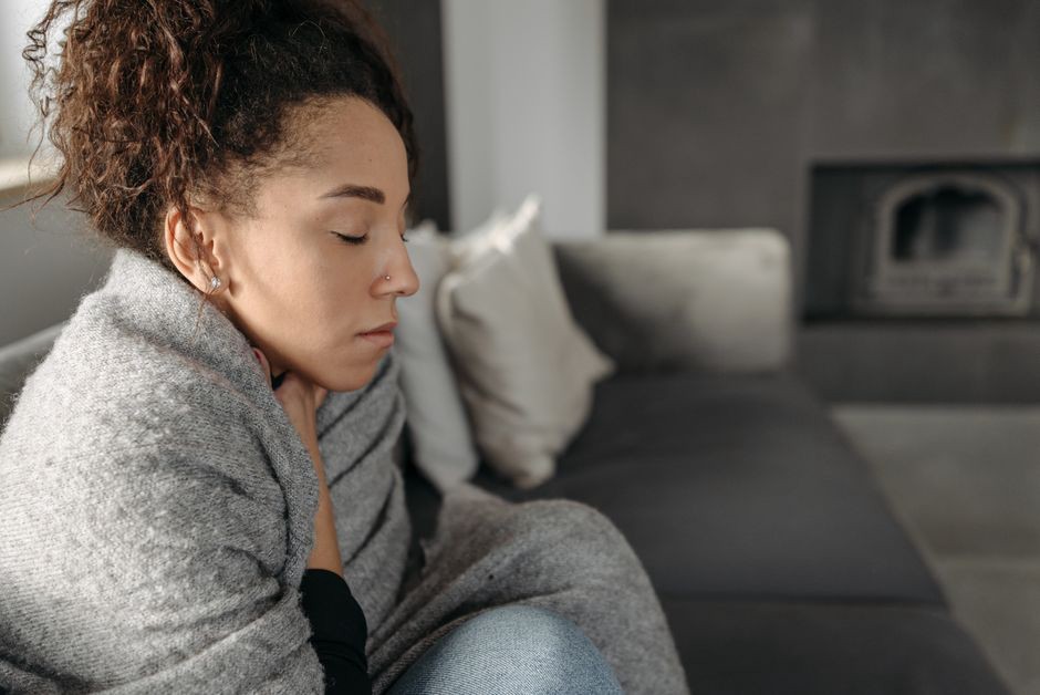 Woman resting at home with signs of fatigue and throat discomfort