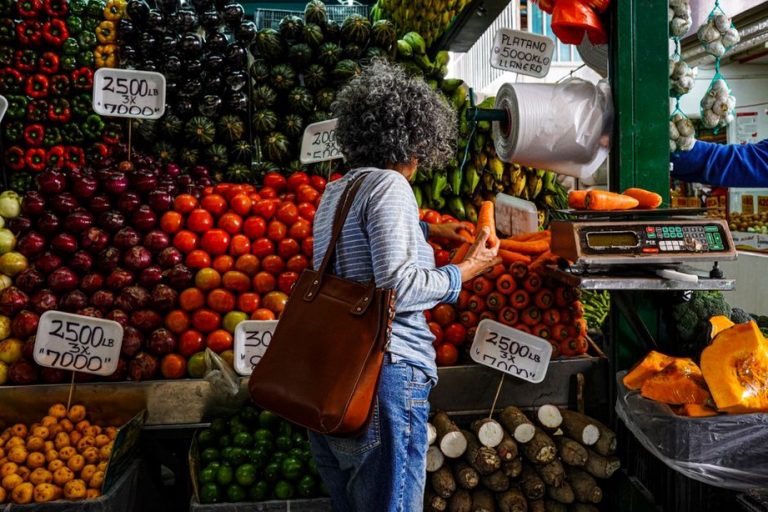 Shoppers selecting seasonal produce at an open-air market abroad