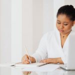 woman writing in food and symptom journal during an elimination diet