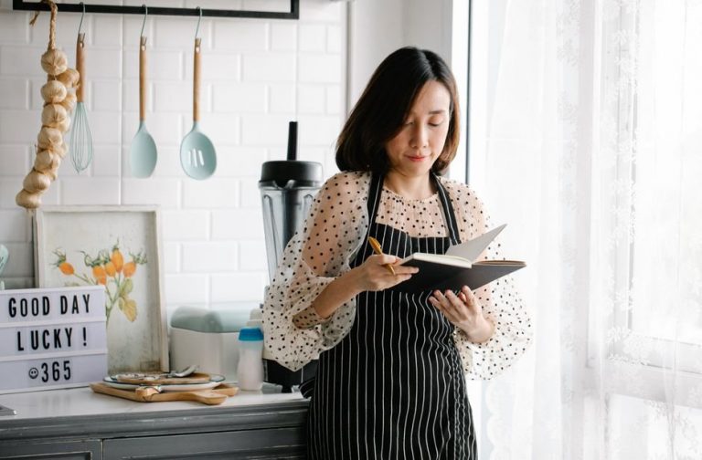 Food diary notebook on a kitchen table with fresh vegetables nearby