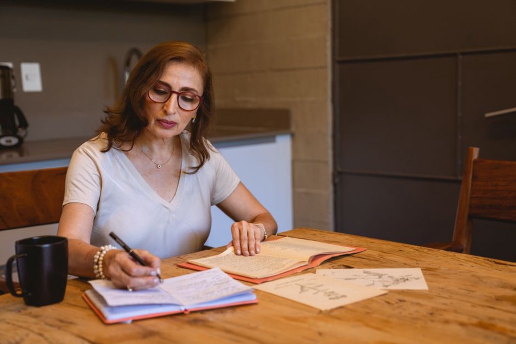 handwritten notes in a spiral notebook next to a glass of water