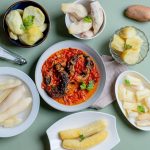 A table with colorful whole-food dishes from several traditions