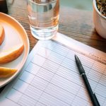 A notebook records meals and digestive symptoms