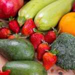 A colorful array of fresh vegetables and fruits on a wooden table
