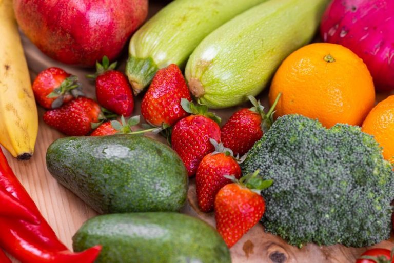 A colorful array of fresh vegetables and fruits on a wooden table