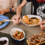 A guest serves themselves from a shared meal