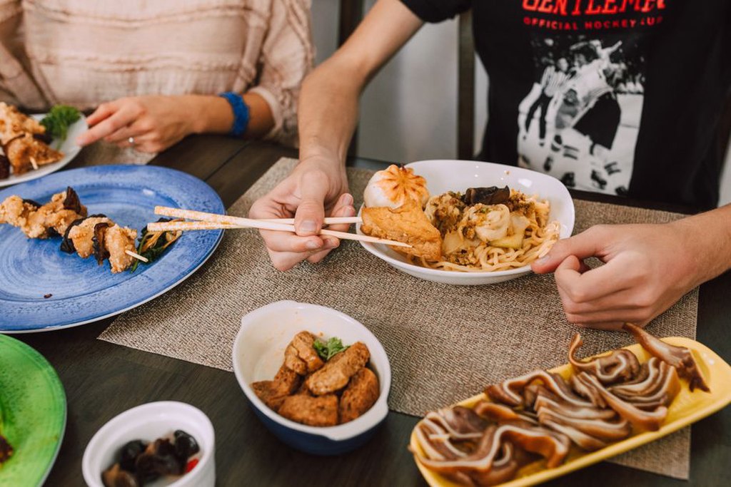 A guest serves themselves from a shared meal