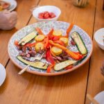 A shared table with simple roasted vegetables and protein
