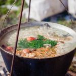 Warm broth served beside a pot of soup