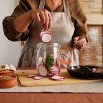 Jars of colorful fermented vegetables on a kitchen counter