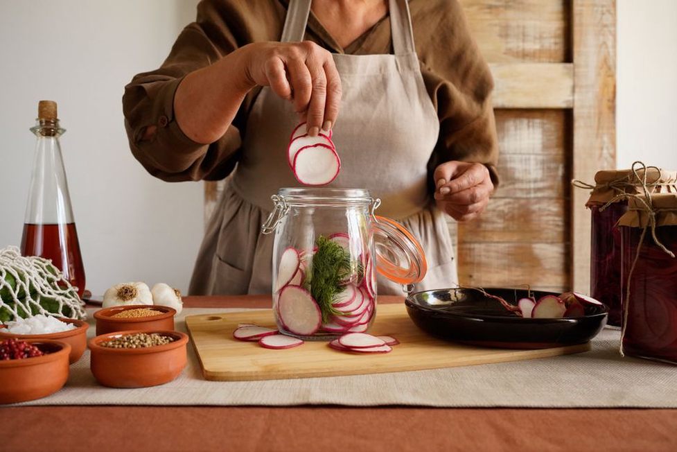 Jars of colorful fermented vegetables on a kitchen counter