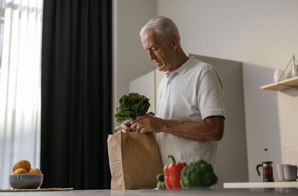 An older adult preparing a varied vegetable meal