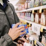 Hands checking ingredients on packaged foods