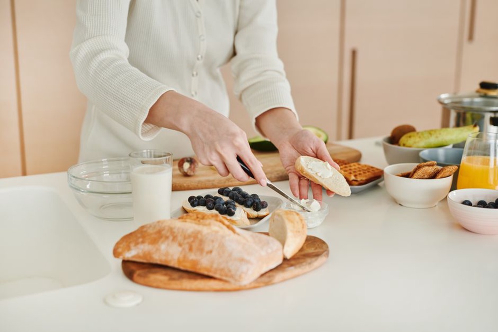 Hands chopping vegetables on a wooden cutting board