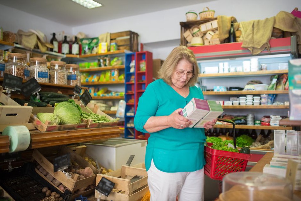A shopper compares a detailed ingredient list