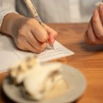 open notebook with meal details and symptom notes beside a simple dinner plate