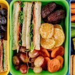 Packed travel foods beside a carry-on bag