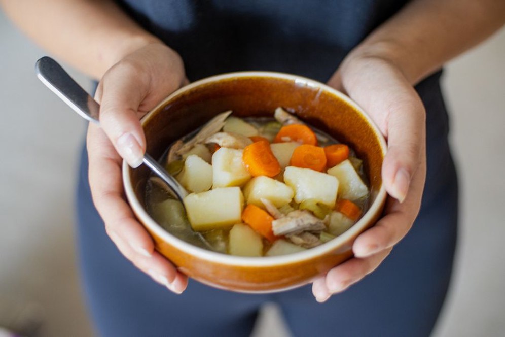 Steaming chicken soup served with tender vegetables