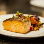 Salmon served with colorful roasted vegetables