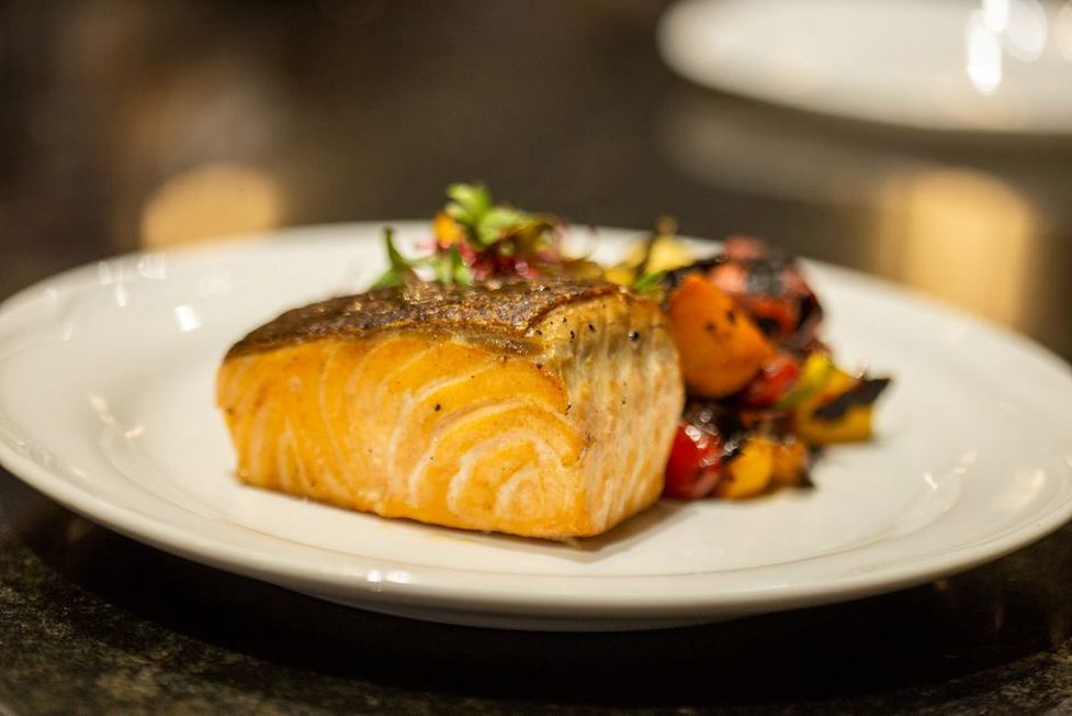 Salmon served with colorful roasted vegetables