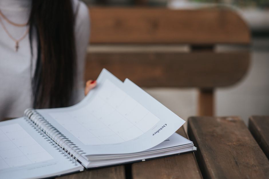 A notebook open beside a weekly calendar