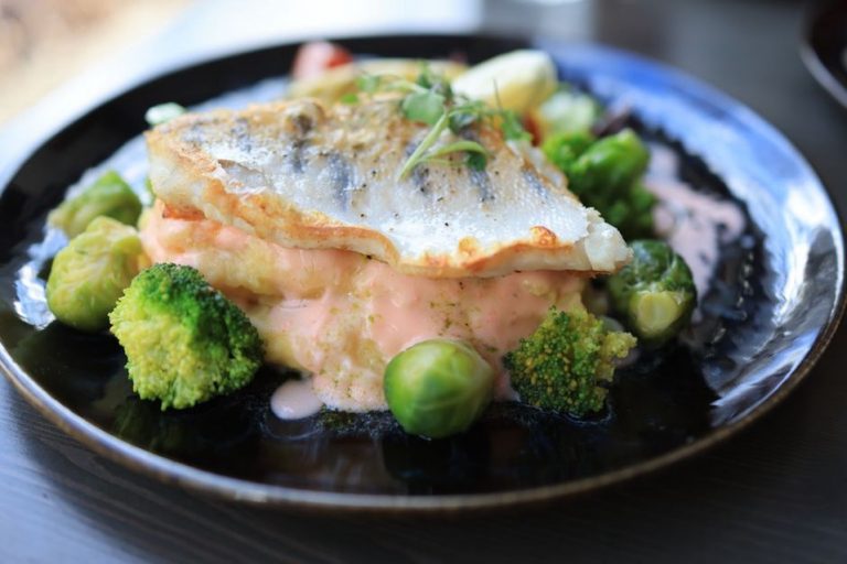 Fish served with a modest portion of cooked vegetables