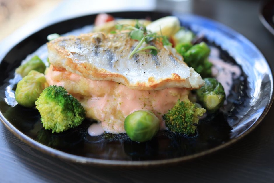 Fish served with a modest portion of cooked vegetables