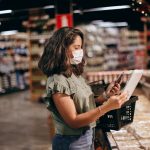 A shopper checks prices beside packaged foods