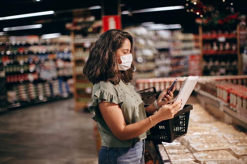 A shopper checks prices beside packaged foods