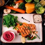 Salmon served with greens and roasted carrots