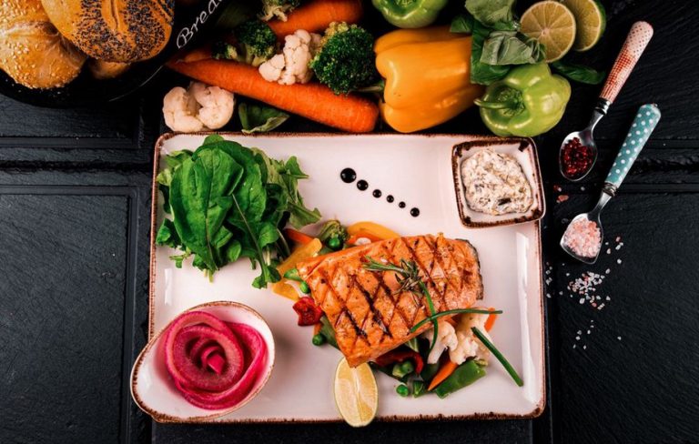 Salmon served with greens and roasted carrots