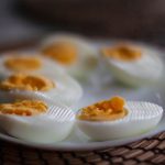 Boiled eggs beside peeled cucumber slices