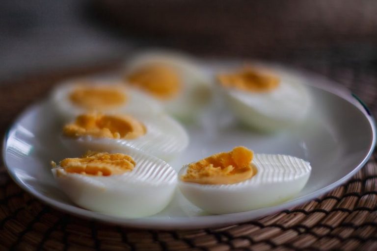 Boiled eggs beside peeled cucumber slices