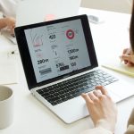 Notebook beside a laptop displaying content trends