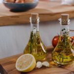Olive oil beside vegetables ready for cooking