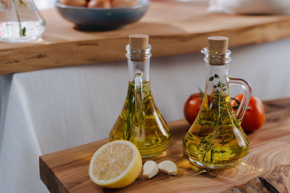 Olive oil beside vegetables ready for cooking